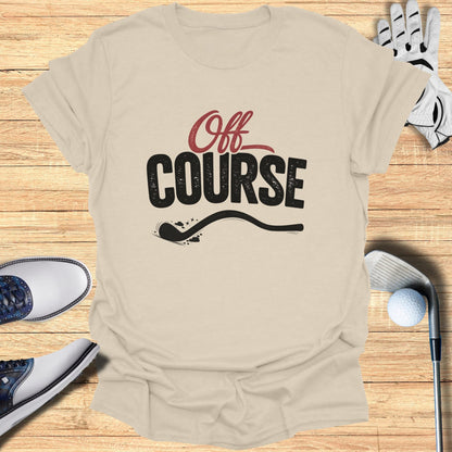 T-shirt with "Off Course" text and golf accessories on a wooden surface.