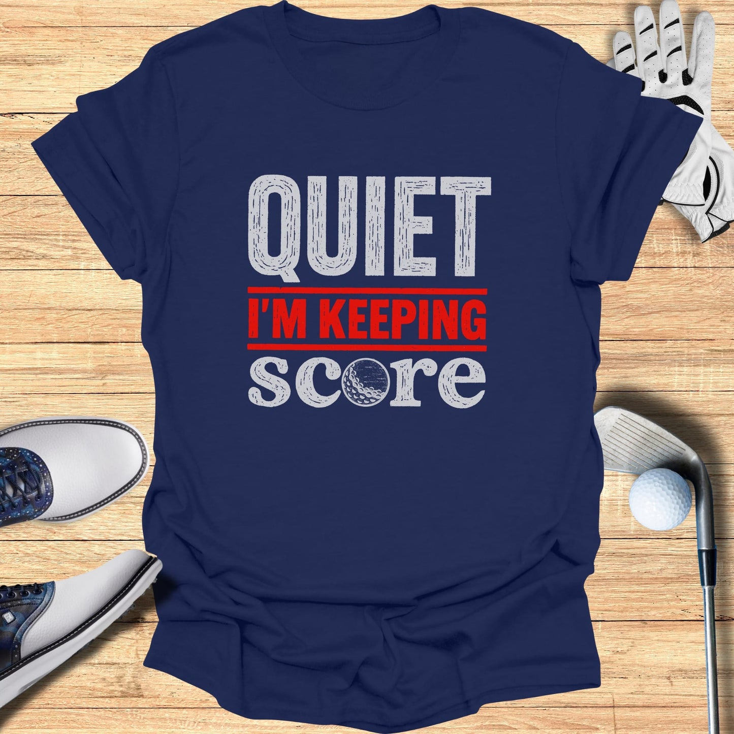 Navy t-shirt with "QUIET I'M KEEPING SCORE" text and golf accessories.