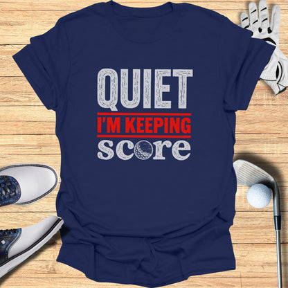 Navy t-shirt with "QUIET I'M KEEPING SCORE" text and golf accessories.