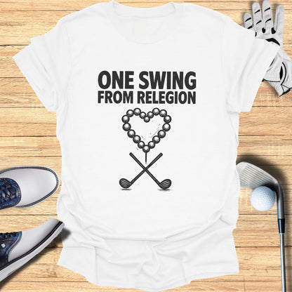 White t-shirt with "ONE SWING FROM RELEGION" and heart made of golf balls.