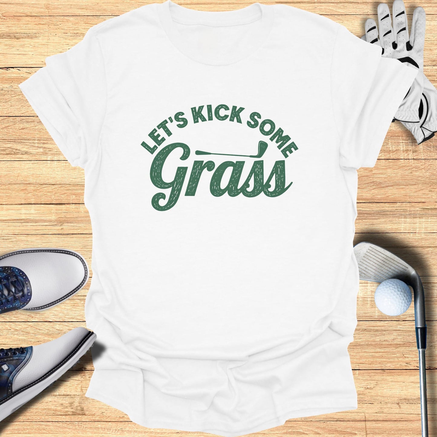 White t-shirt with green text "LET'S KICK SOME Grass".
