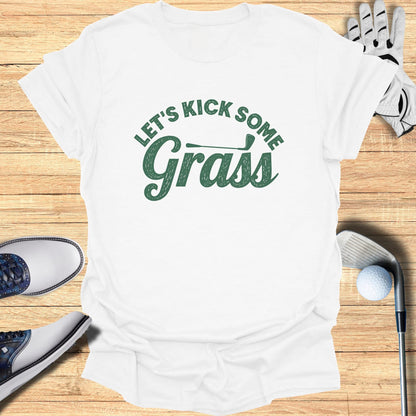 White t-shirt with green text "LET'S KICK SOME Grass".