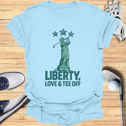 Light blue t-shirt with Statue of Liberty golfing and text "Liberty, Love & Tee Off".