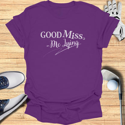 Purple t-shirt with "GOOD Miss. -Me Lying" text, golf club and ball.