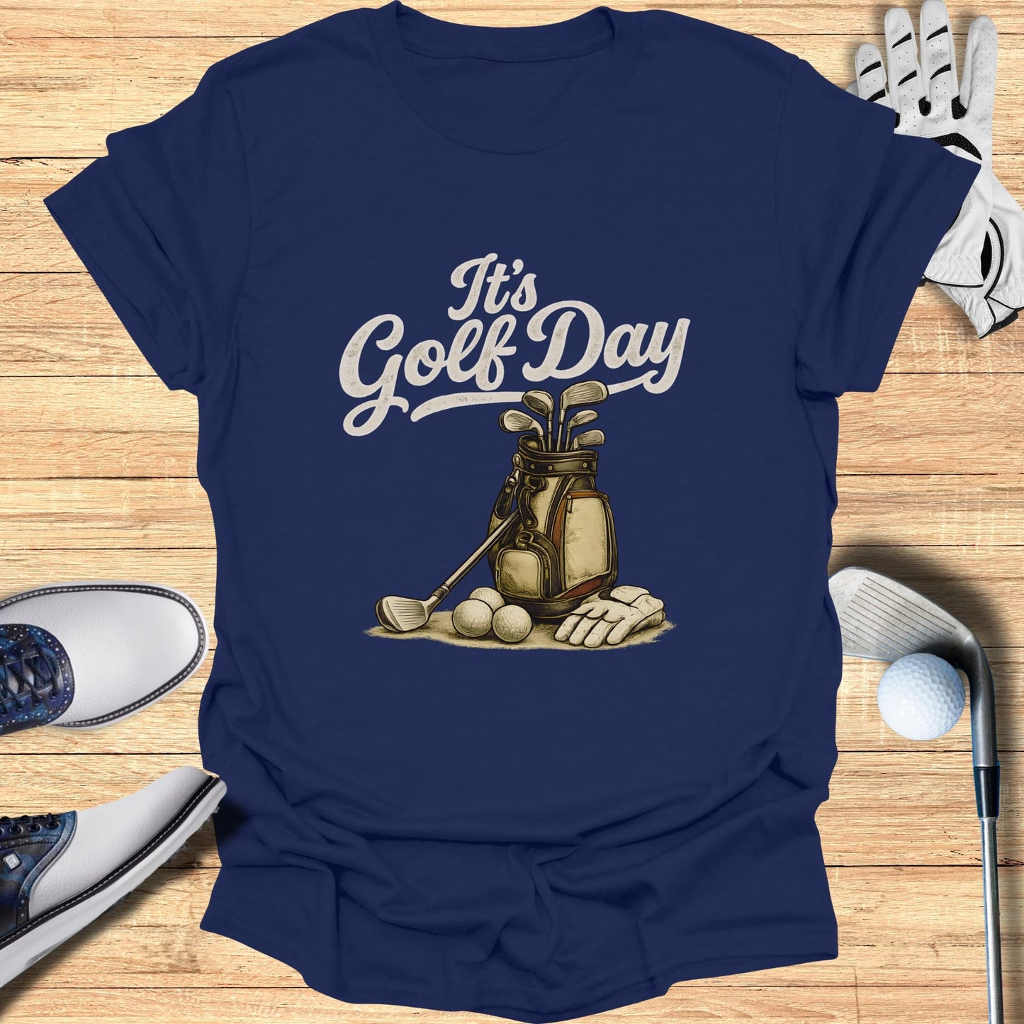 Navy t-shirt with "It's Golf Day" text, golf bag, clubs, and balls.