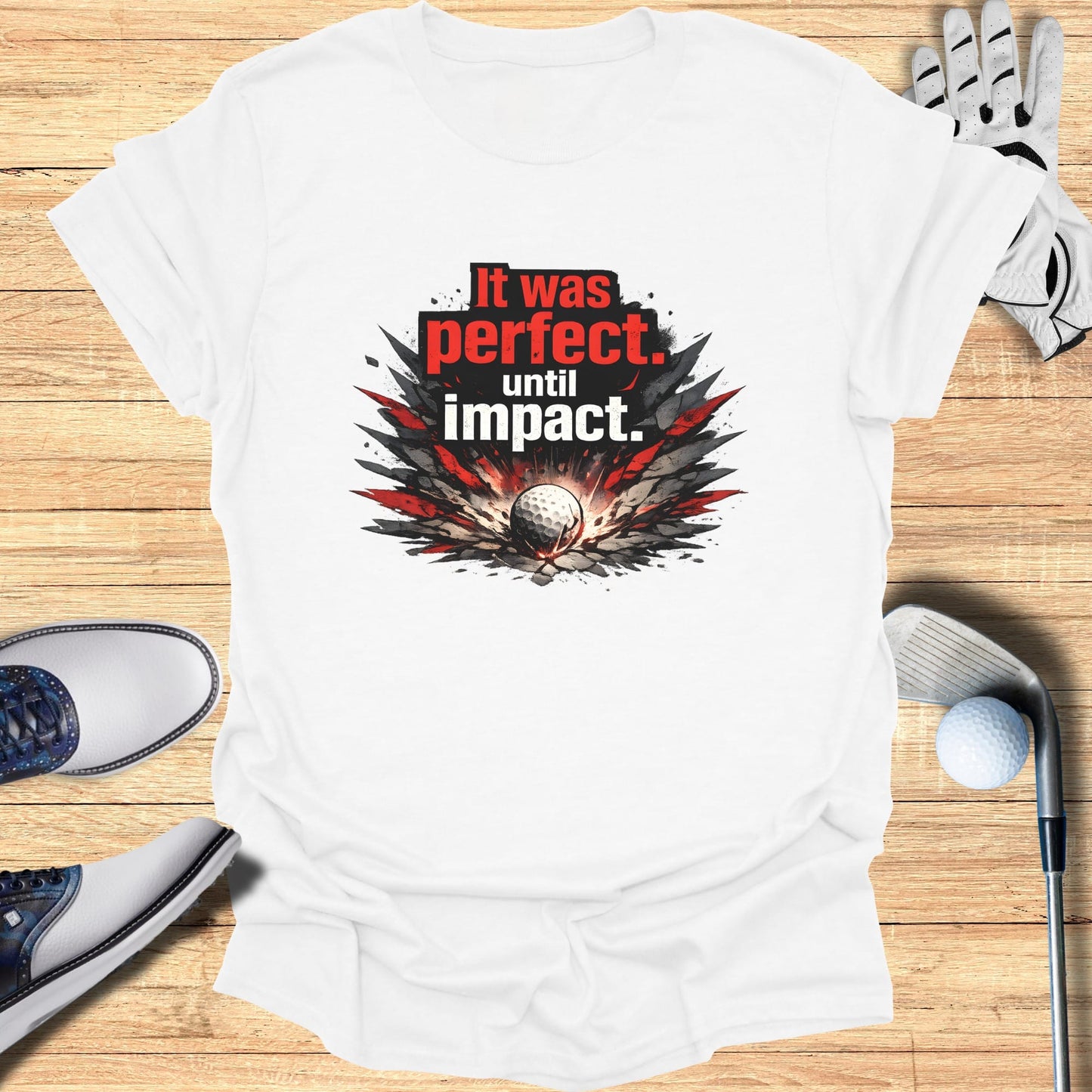 White t-shirt with "It was perfect. Until impact." golf graphic.