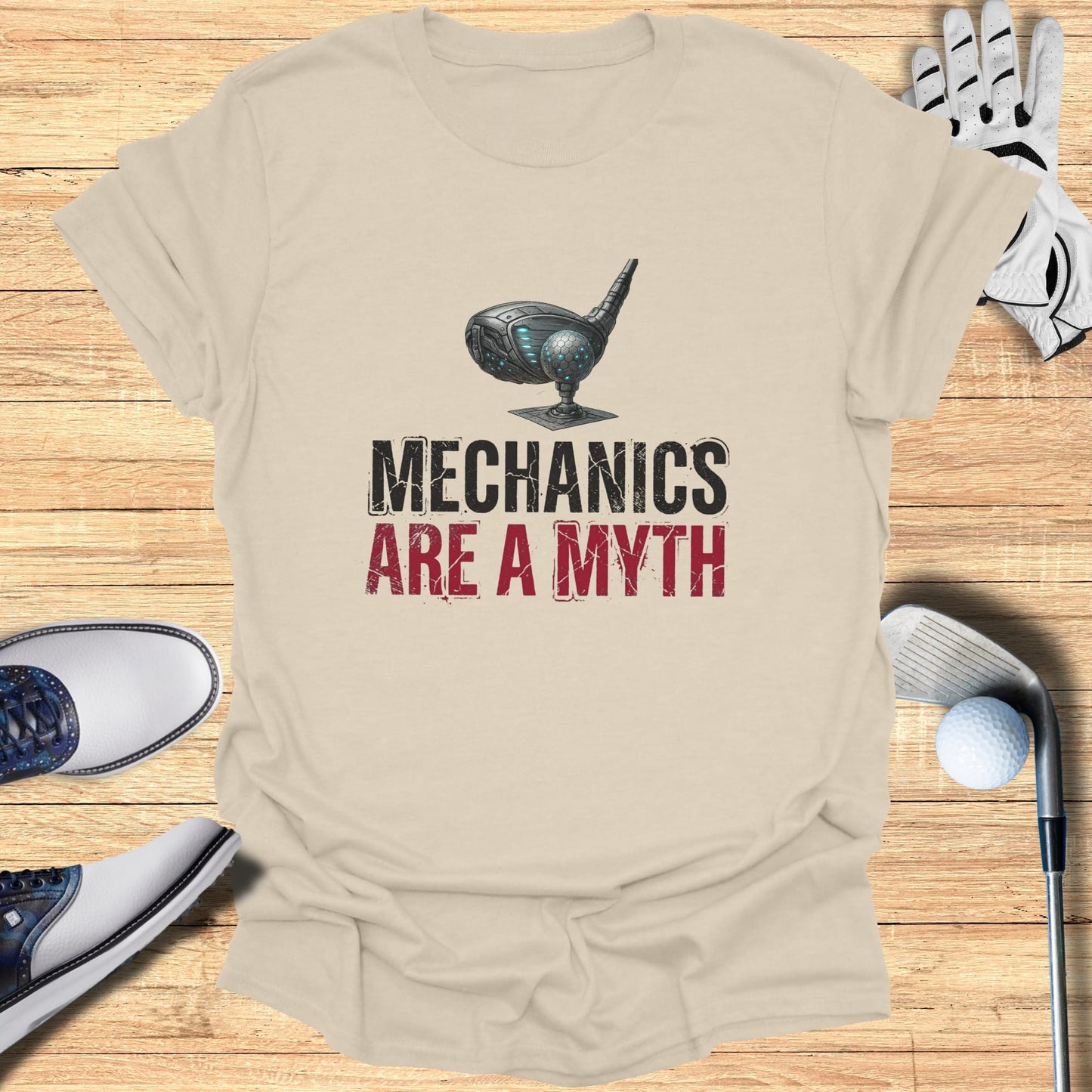 Light beige t-shirt with "Mechanics Are A Myth" graphic and golf accessories.
