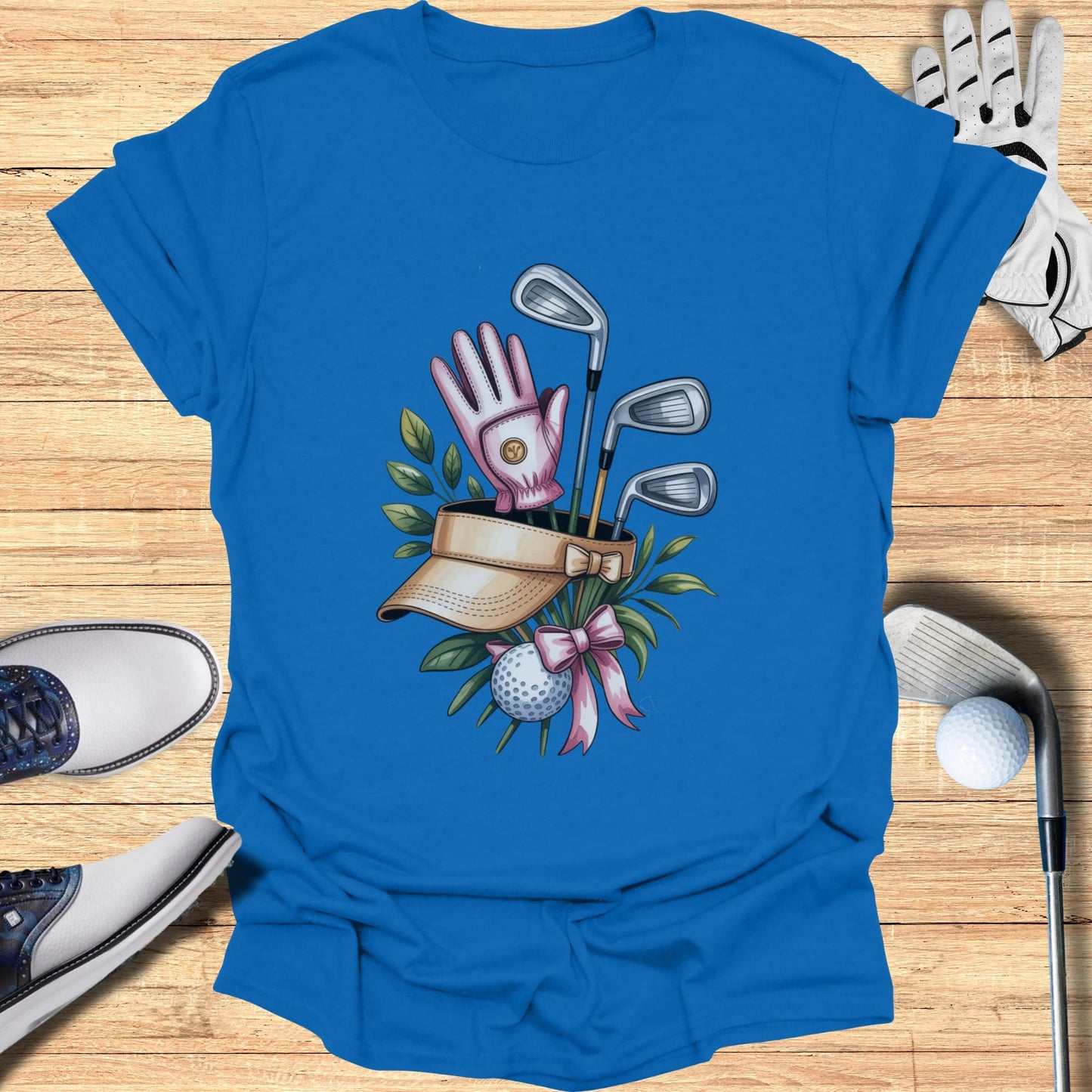 Golf clubs, visor, glove, and ball with pink bow on blue shirt.