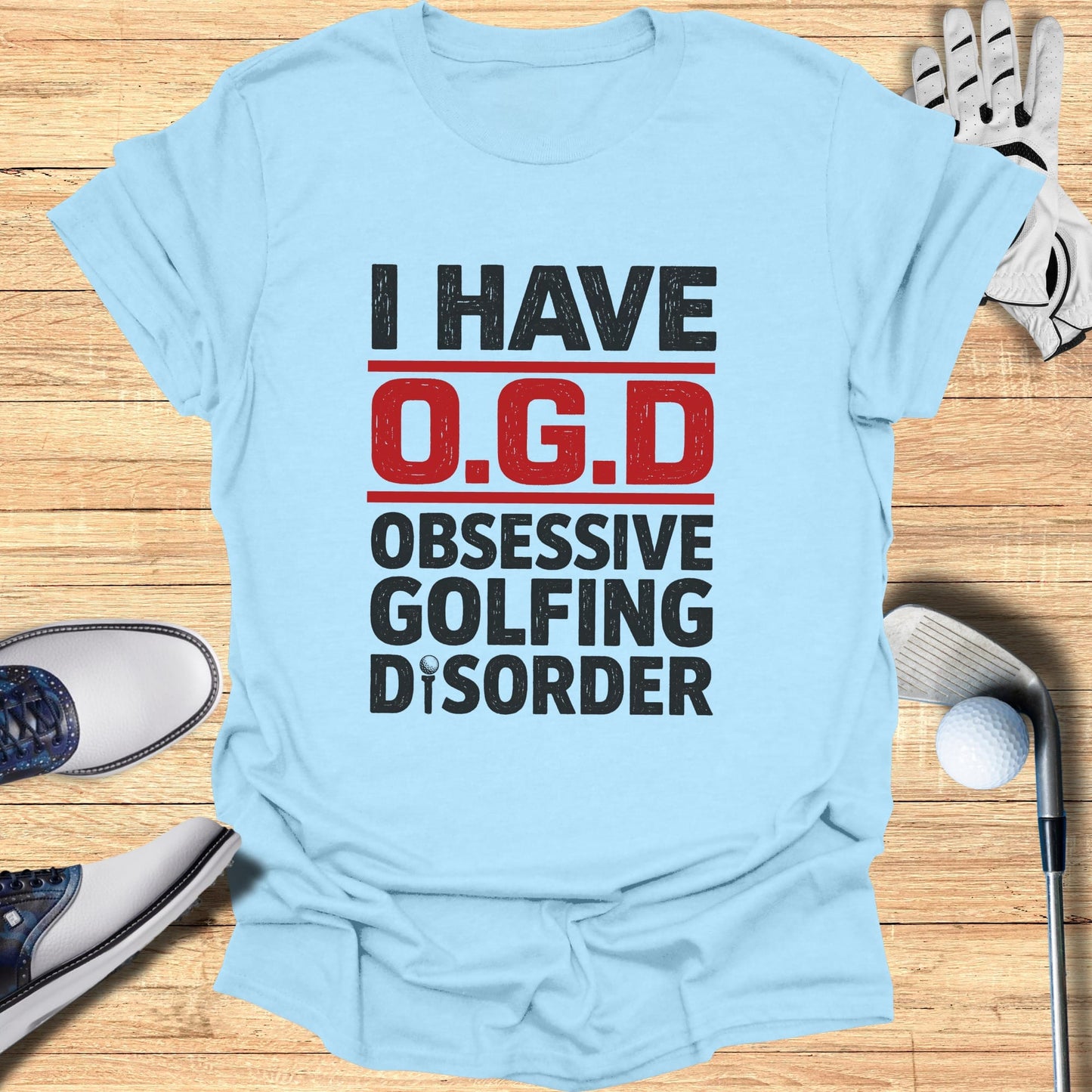 Light blue t-shirt with bold black text: "I HAVE O.G.D. OBSESSIVE GOLFING DISORDER".