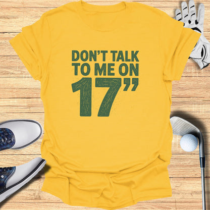 Yellow t-shirt with "Don't talk to me on 17" text and golf accessories.