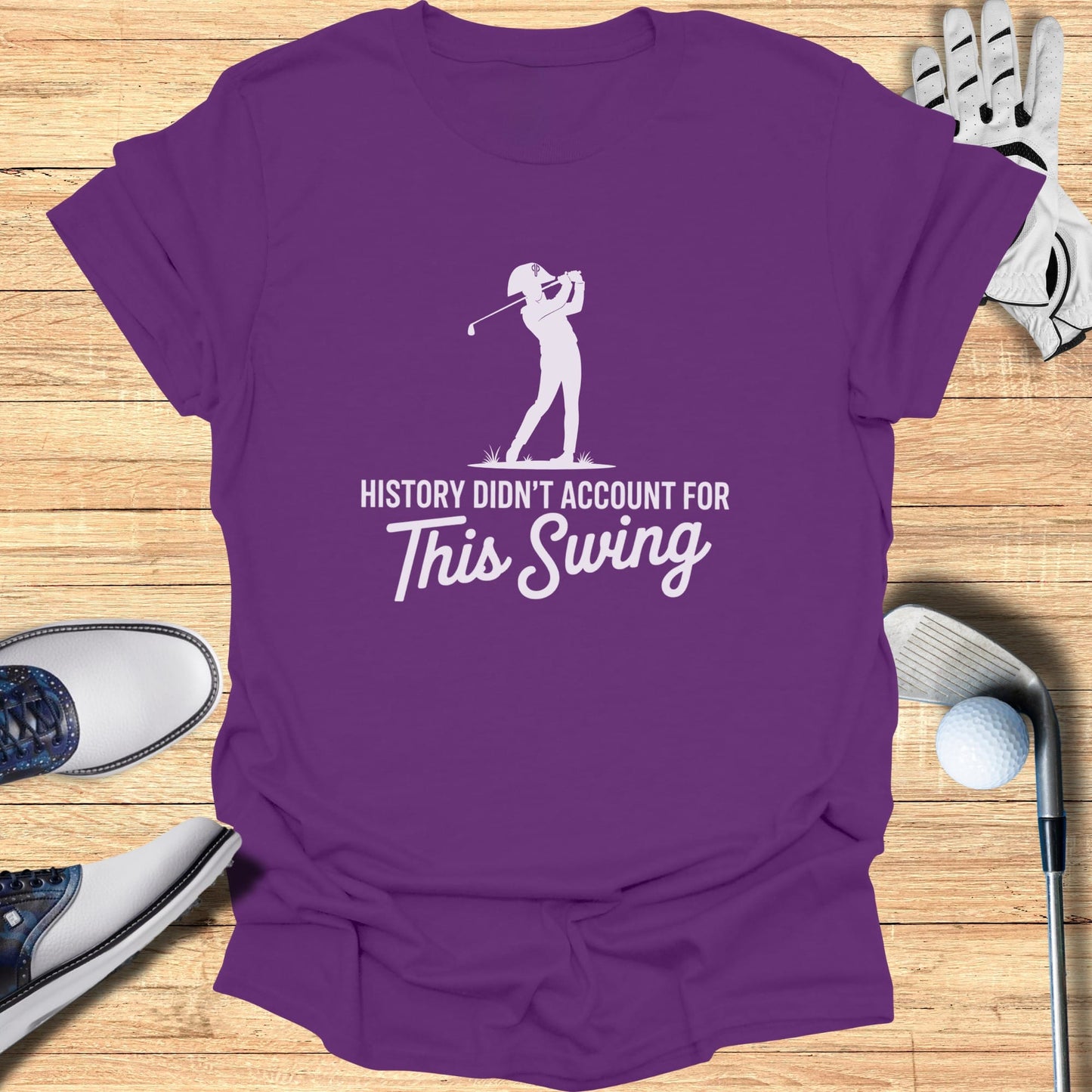 Purple t-shirt with "History Didn't Account For This Swing" text and golfer graphic.