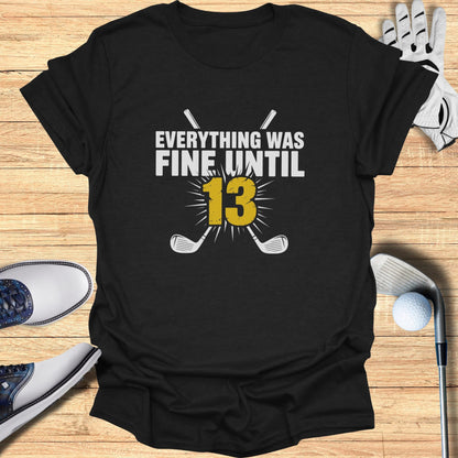 Black t-shirt with "Everything was fine until 13" and crossed golf clubs.