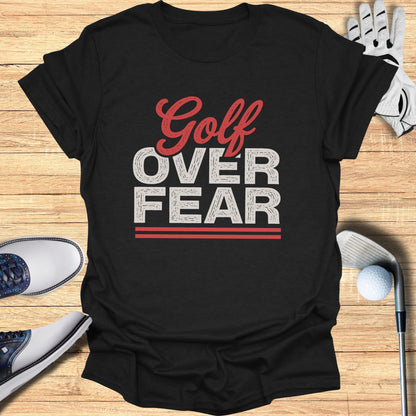 Black t-shirt with "Golf Over Fear" text, golf shoes, and golf club.