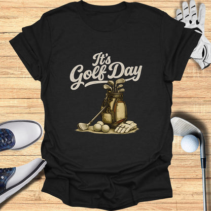 Black t-shirt with "It's Golf Day" text and golf bag with clubs.