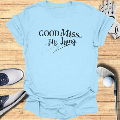 Light blue t-shirt with "GOOD Miss. -Me Lying" text, featuring golf accessories.