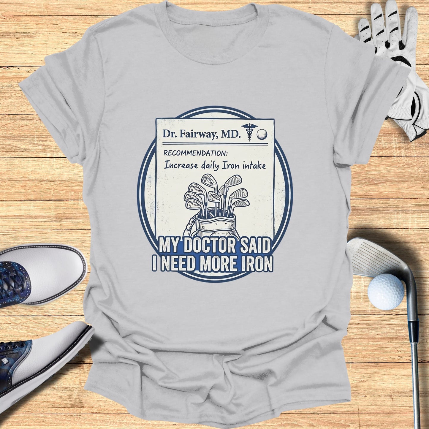 T-shirt with "Dr. Fairway, MD. RECOMMENDATION: Increase daily Iron intake MY DOCTOR SAID I NEED MORE IRON" and golf clubs.