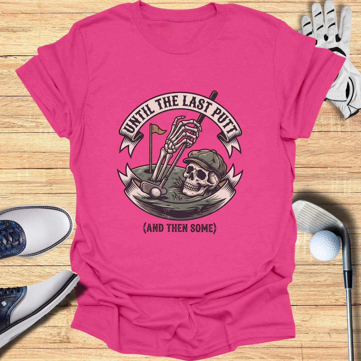 Pink t-shirt with skeleton golfer graphic and text "UNTIL THE LAST PUTT (AND THEN SOME)".