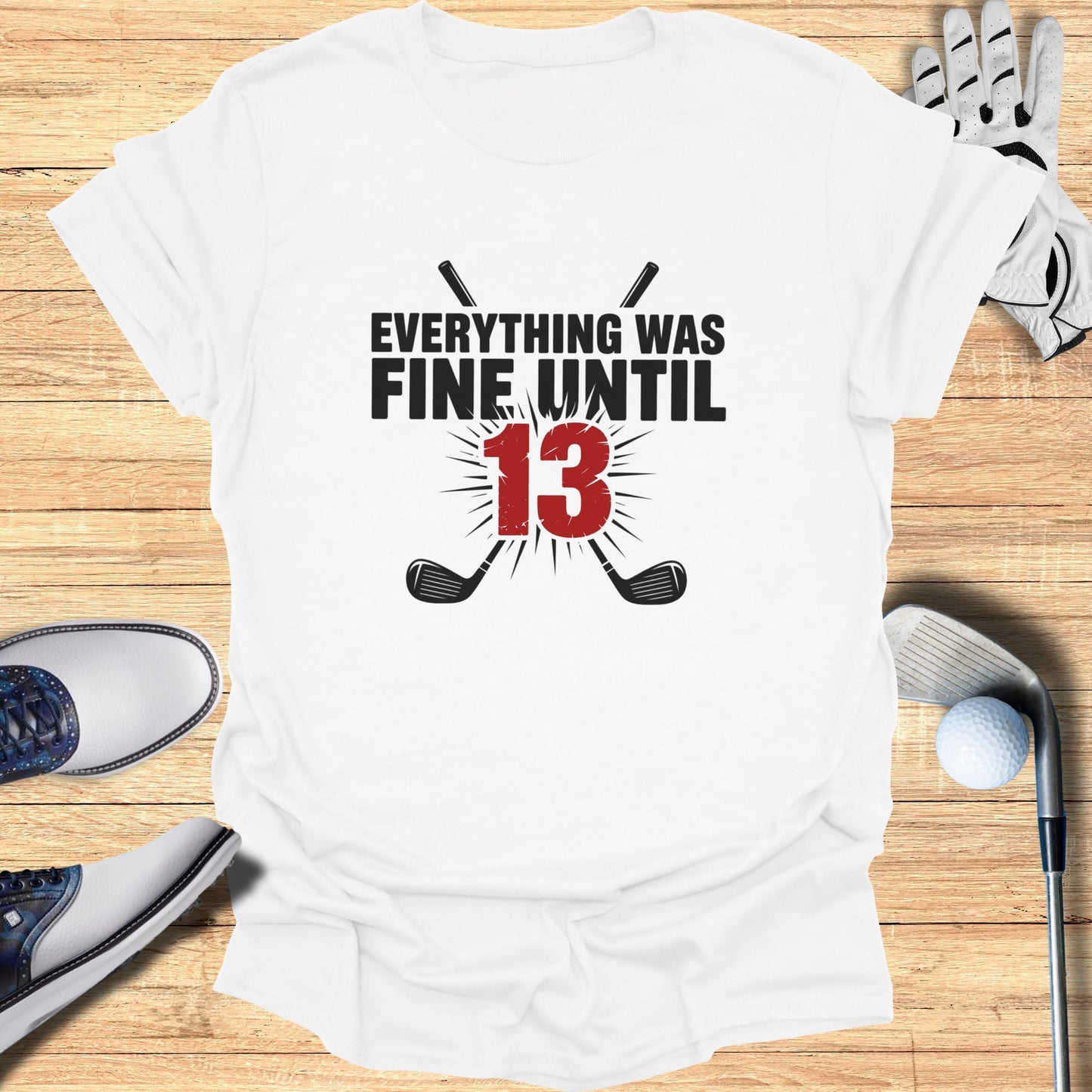 White t-shirt with "EVERYTHING WAS FINE UNTIL 13" and crossed golf clubs.