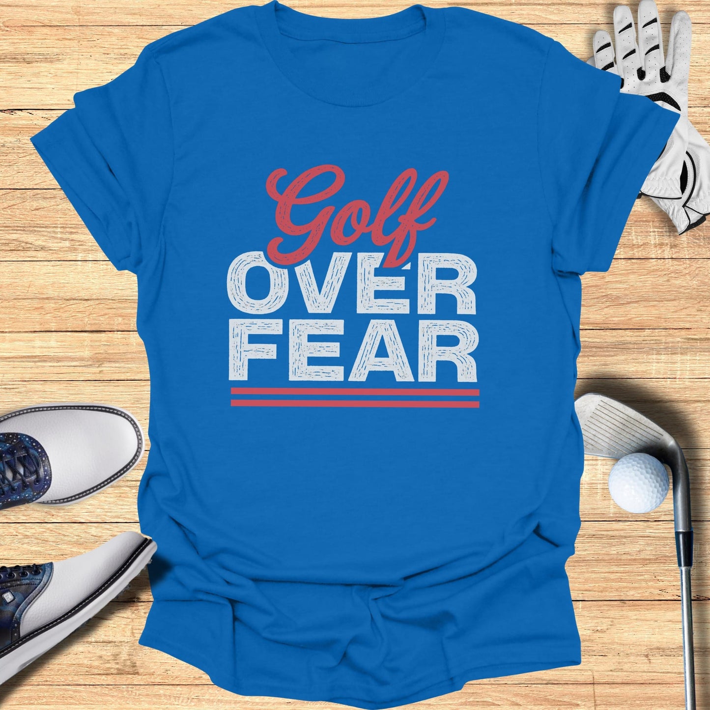 Blue t-shirt with "Golf Over Fear" text and golf equipment.