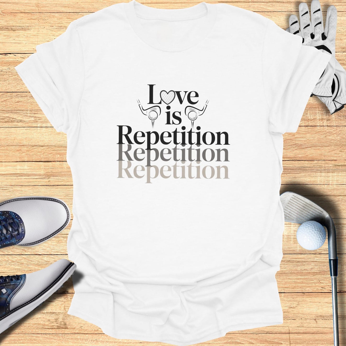 White t-shirt with "Love is Repetition Repetition Repetition" text and golf accessories.