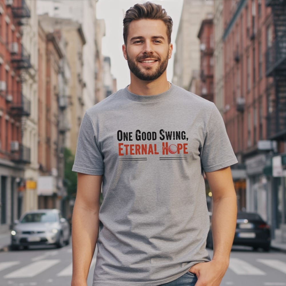 Man wearing gray t-shirt with "One Good Swing, Eternal Hope" and golf ball graphic.