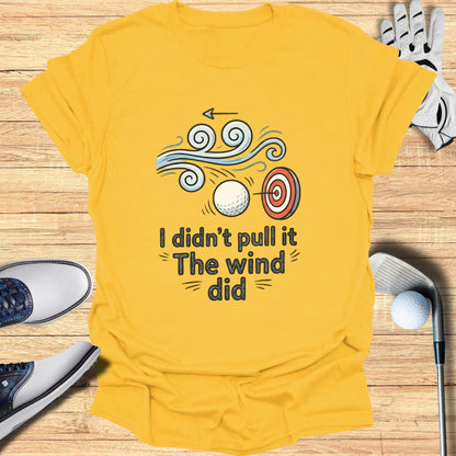 Yellow t-shirt with graphic of target, golf ball, and wind with text "I didn't pull it The wind did".
