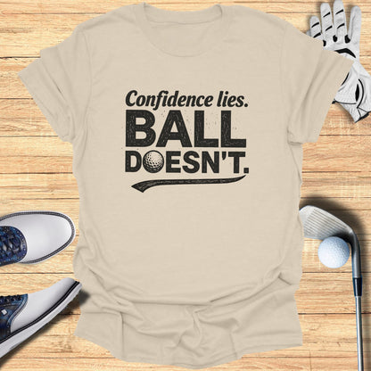 Beige t-shirt with "Confidence lies. BALL DOESN'T." text and golf accessories.
