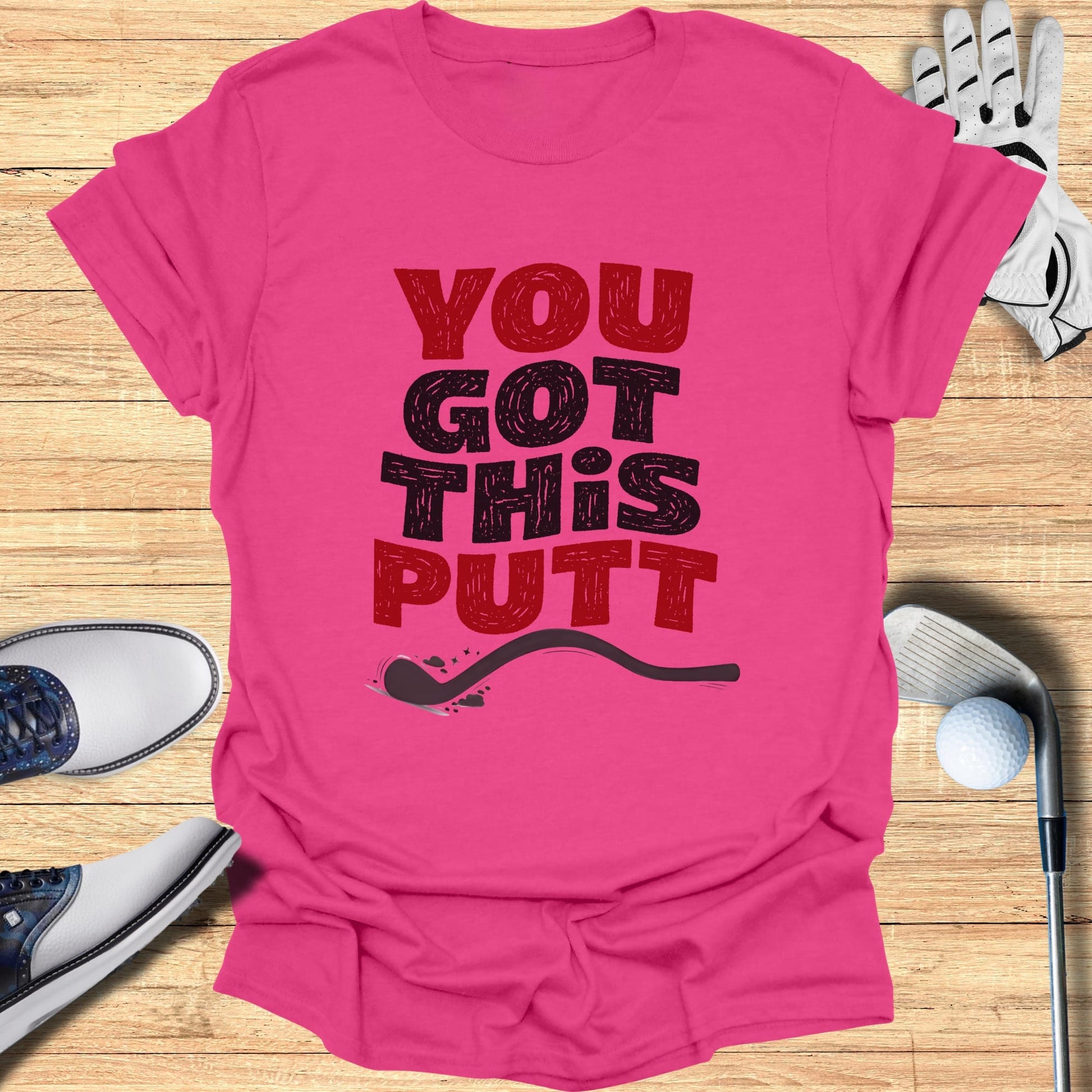 Pink t-shirt with "YOU GOT THIS PUTT" text and golf accessories.