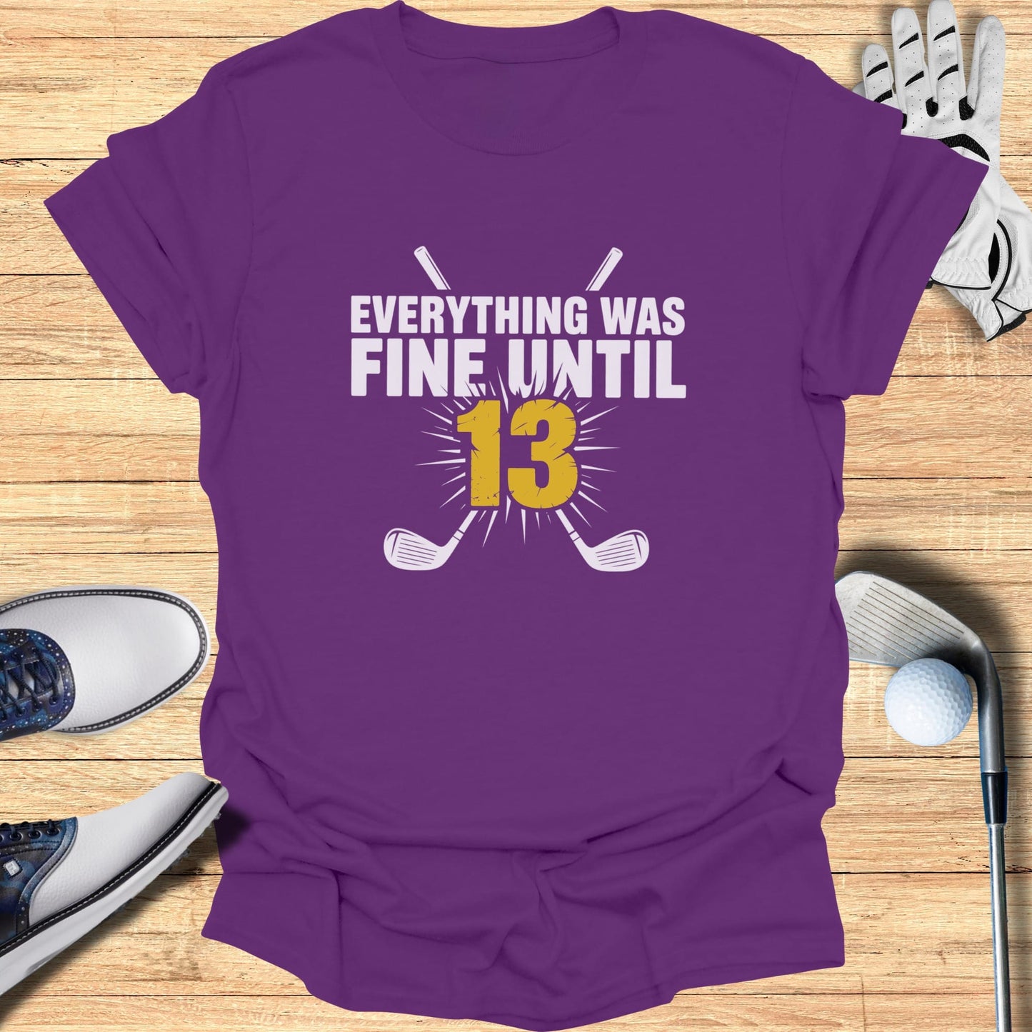 Purple t-shirt with "Everything was fine until 13" and crossed golf clubs graphic.