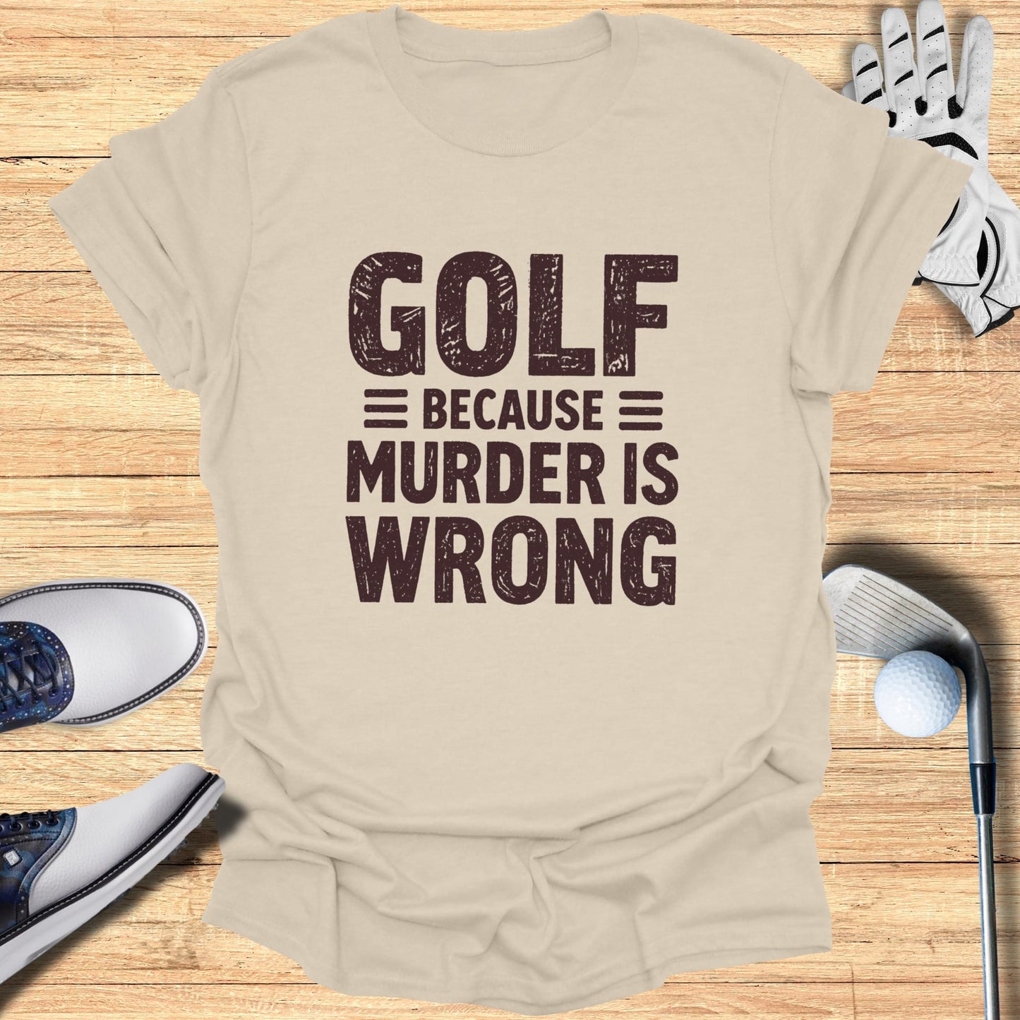 T-shirt with "GOLF BECAUSE MURDER IS WRONG" text, surrounded by golf equipment.