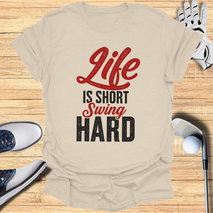 T-shirt with "Life Is Short Swing Hard" text, golf shoes, glove, and club.