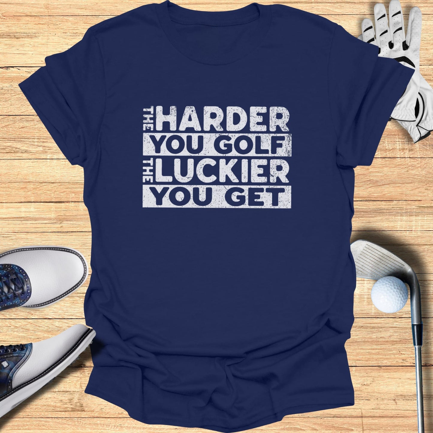 Navy t-shirt with "the harder you golf the luckier you get" text.