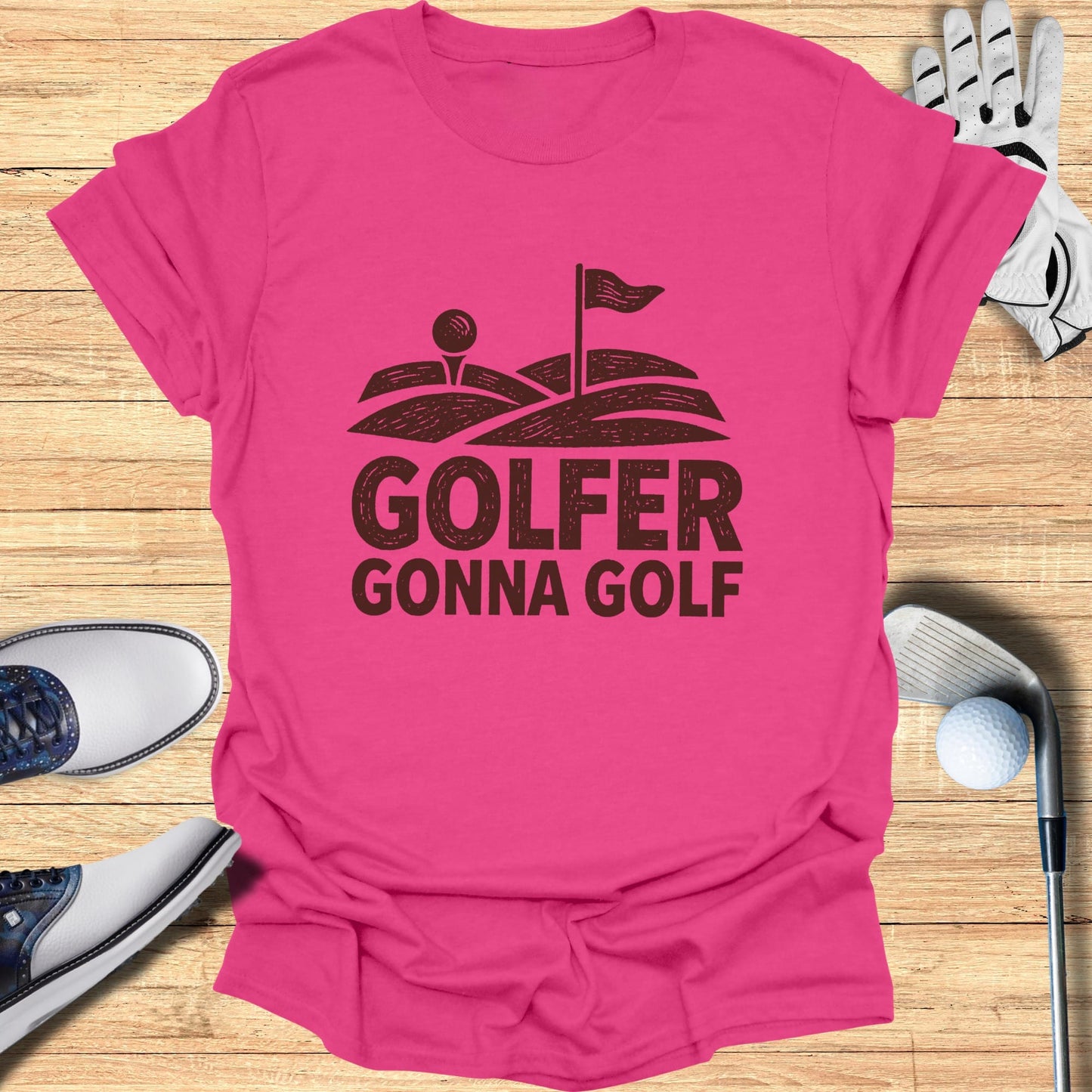 Pink t-shirt with "Golfer Gonna Golf" graphic and golf equipment.