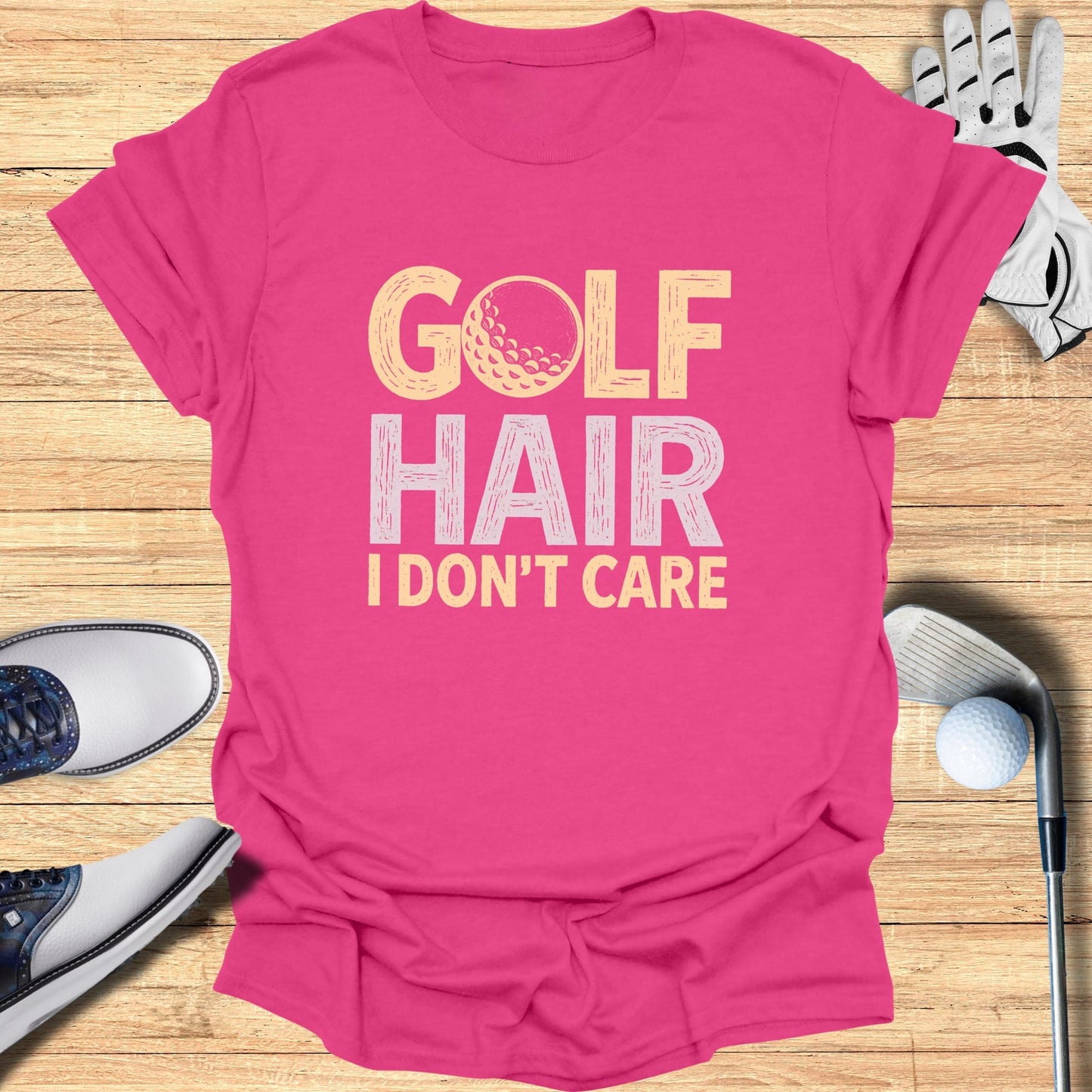 Pink t-shirt with "GOLF HAIR I DON'T CARE" text and golf ball graphic.