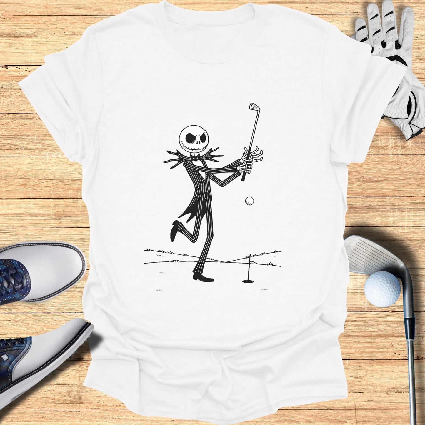Black and white illustration of Jack Skellington playing golf on a white t-shirt.