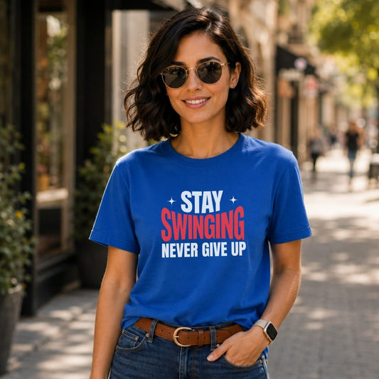 Woman in blue t-shirt with "STAY SWINGING NEVER GIVE UP" text.