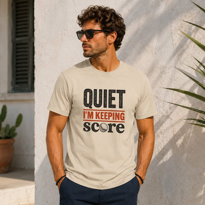 Man wearing a light tan t-shirt with "QUIET I'M KEEPING SCORE" and golf ball graphic.