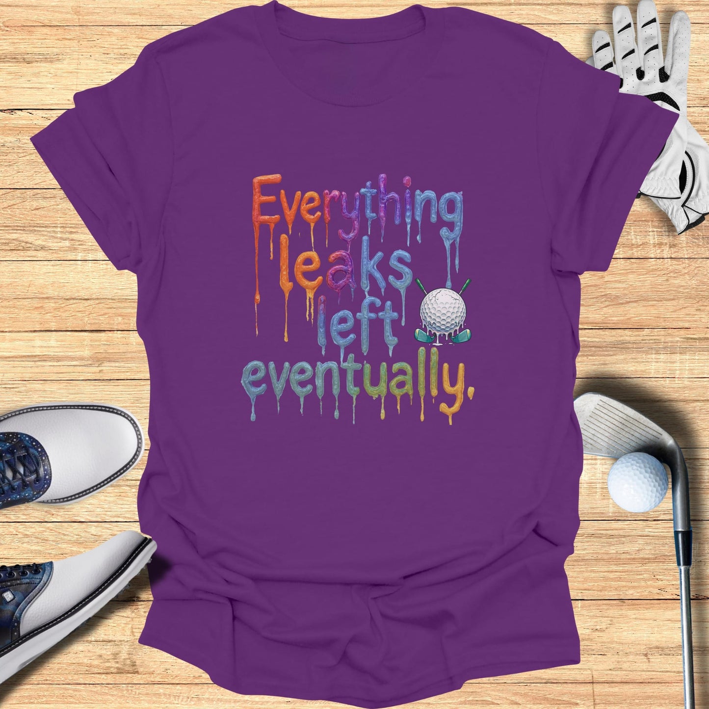 Purple t-shirt with dripping text "Everything leaks eventually" and a golf ball on tee.