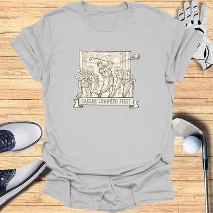 T-shirt graphic with "Caesar Shanked First" text and Roman-inspired golfers.