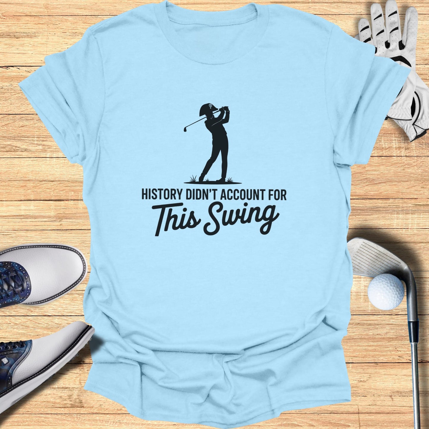Light blue t-shirt with a black silhouette of a golfer and text "HISTORY DIDN'T ACCOUNT FOR THIS SWING".