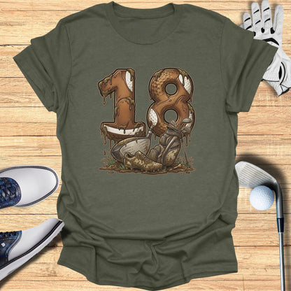 Muddy football-shaped "18" with golf clubs and shoes on wooden background.