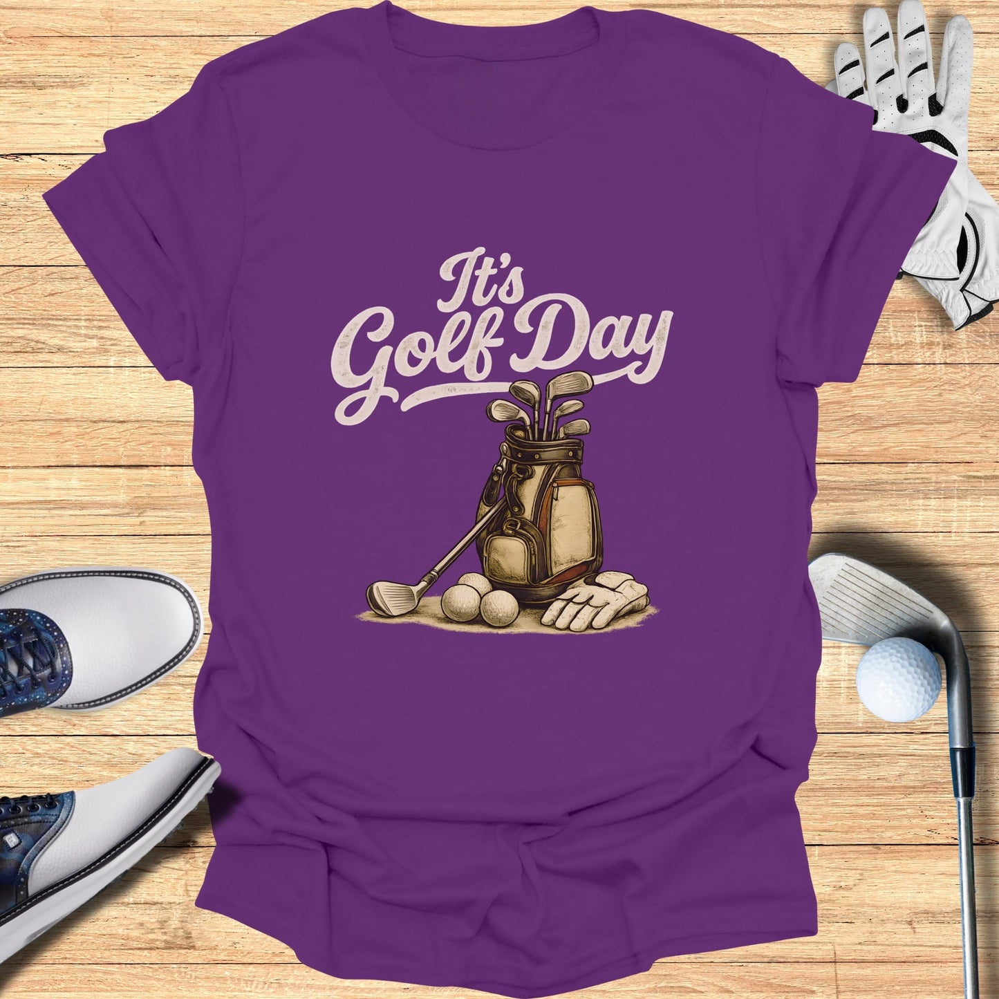 Purple t-shirt with "It's Golf Day" graphic of golf bag, clubs, balls, and glove.