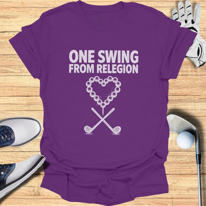 Purple t-shirt with "ONE SWING FROM RELEGION" text and crossed golf clubs.