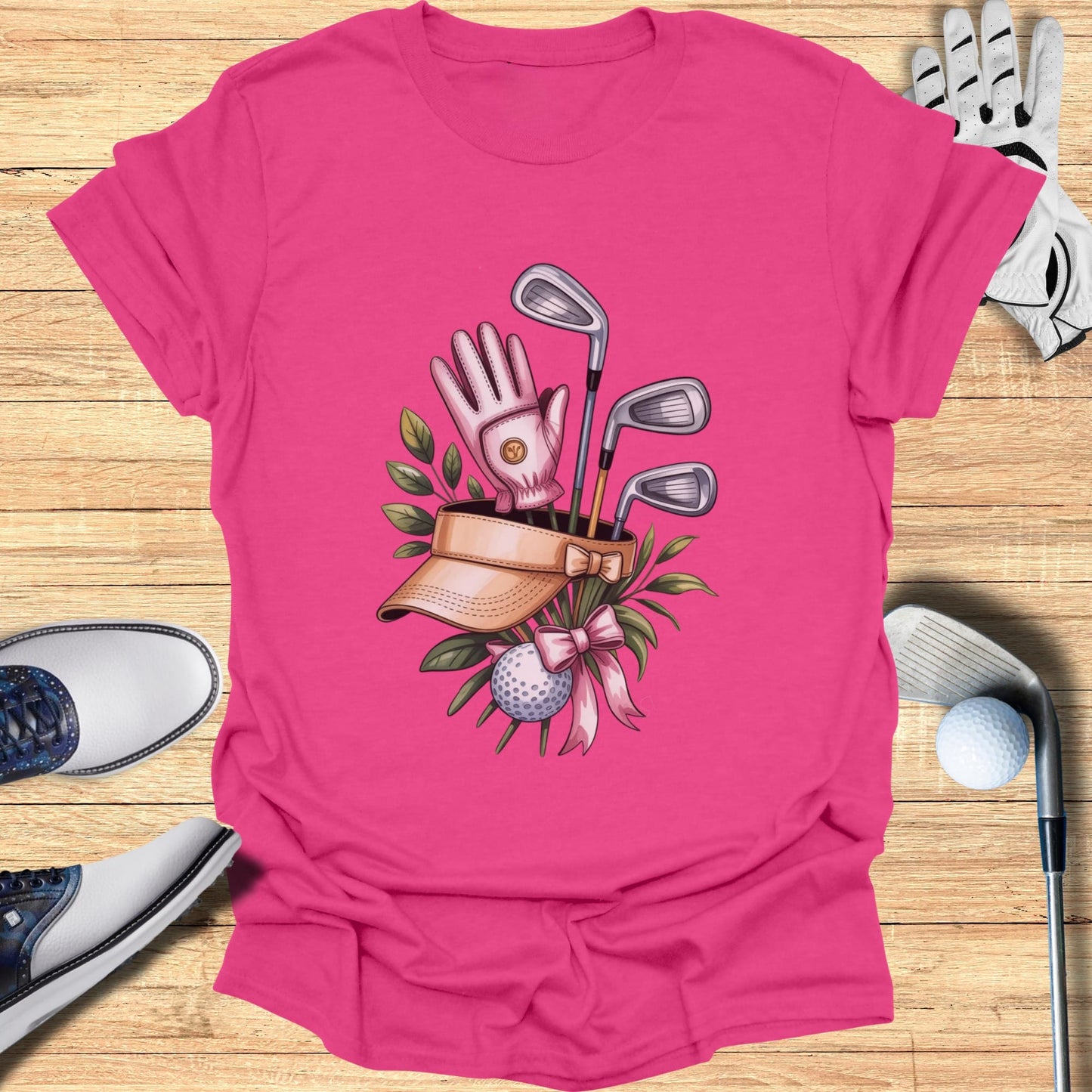 Pink t-shirt with golf clubs, glove, ball, and visor graphic.