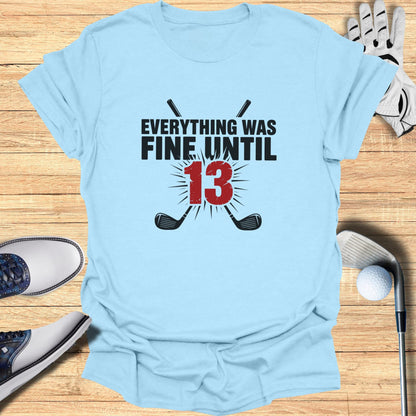 Light blue t-shirt with "Everything Was Fine Until 13" and crossed golf clubs graphic.